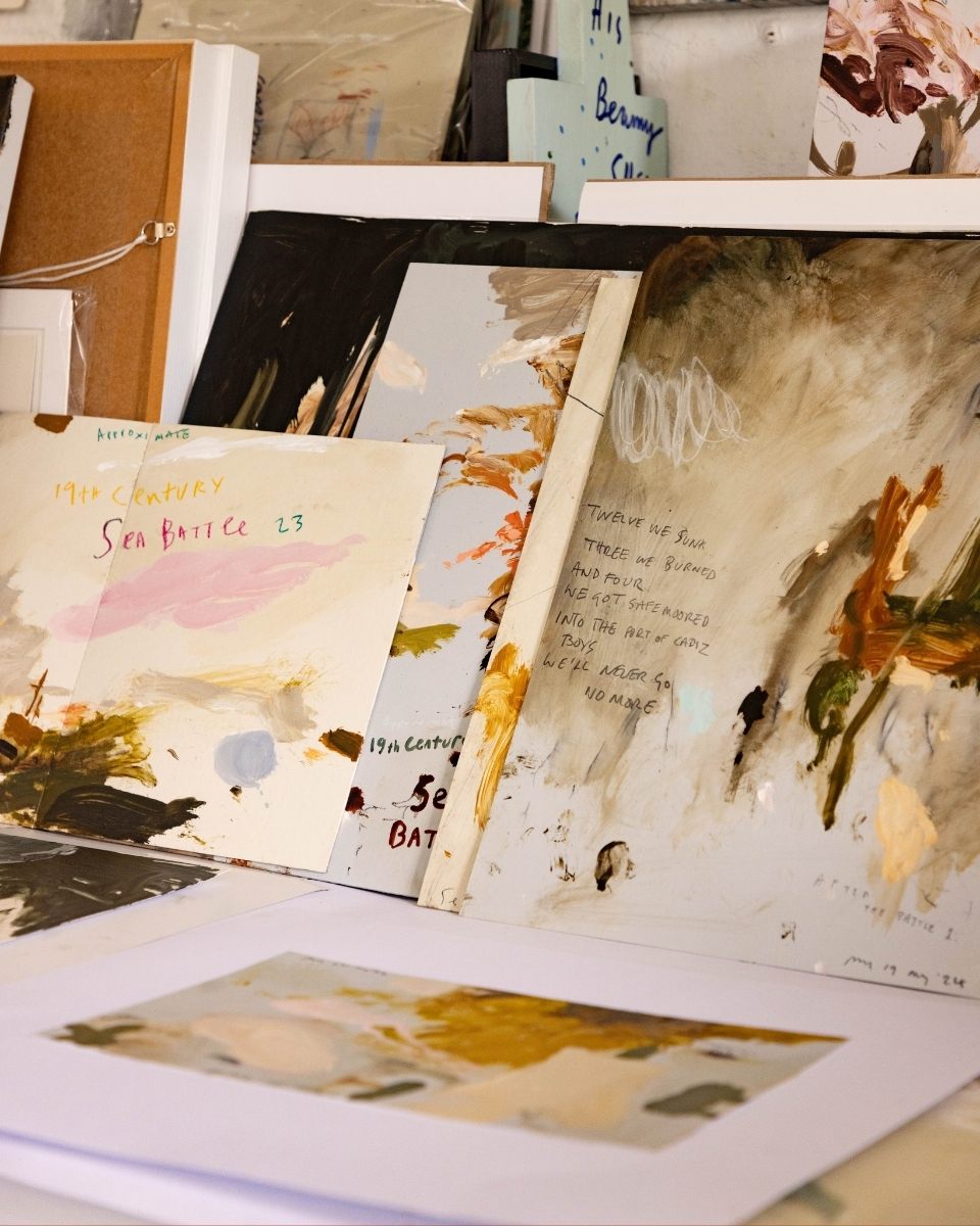 Close-up detail of Philip Maltman’s studio corner, with multiple oil paintings and drawings leaning together in a layered display.