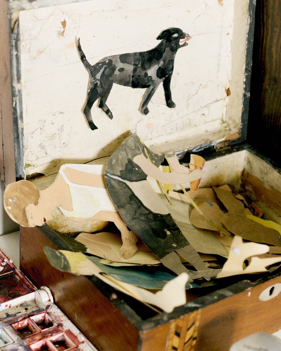 Intricate handmade paper figurines arranged inside a wooden storage box by artist Phoebe Howard.