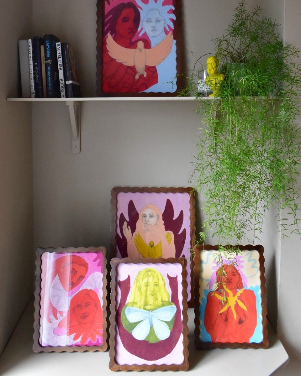 A curated studio shelf display featuring multiple framed artworks by Rebecca Sammon, showcasing her bold use of colour and form.