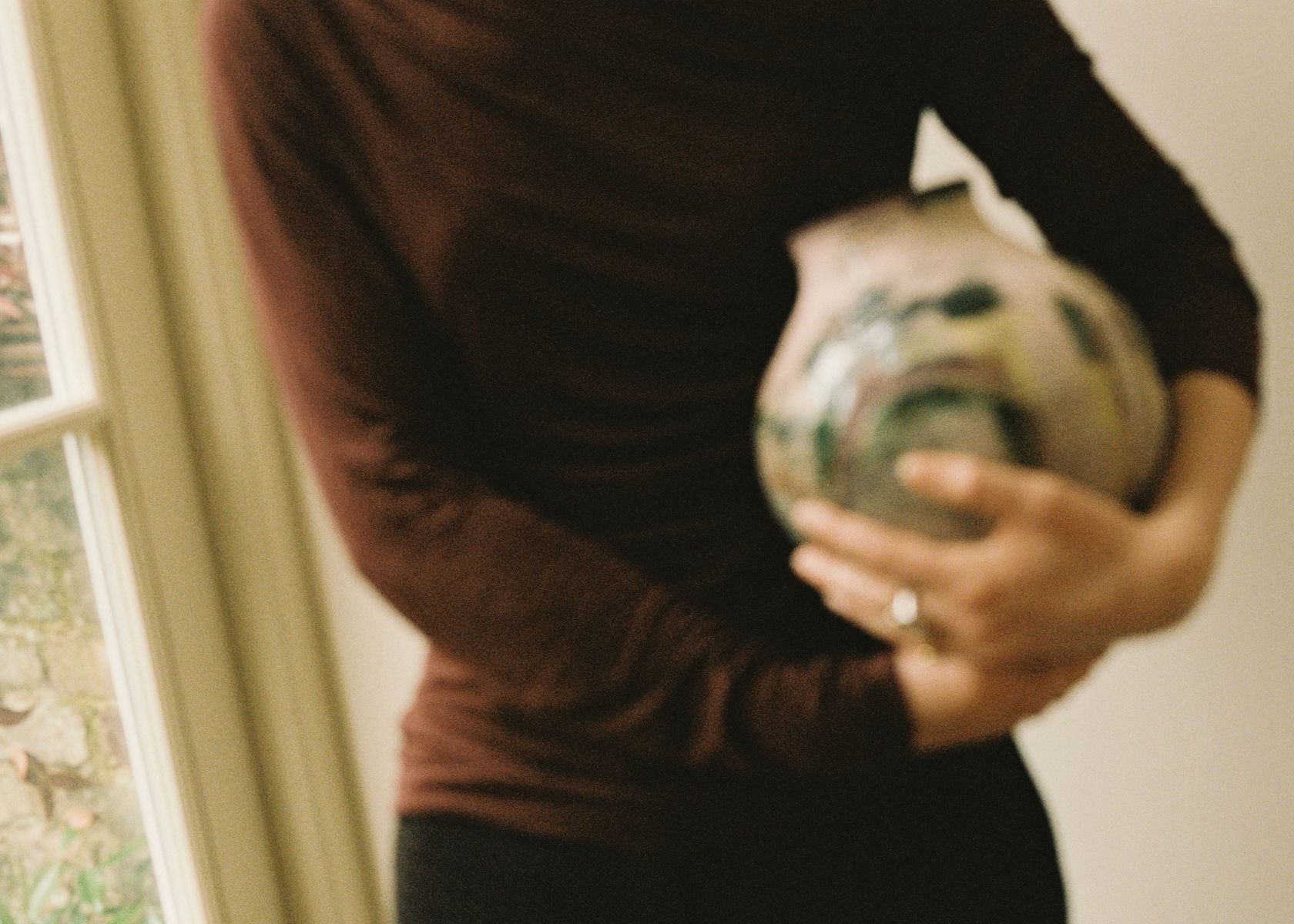 Georgia Spray carefully handling a Partnership Editions artist vase, representing our returns and quality check process.