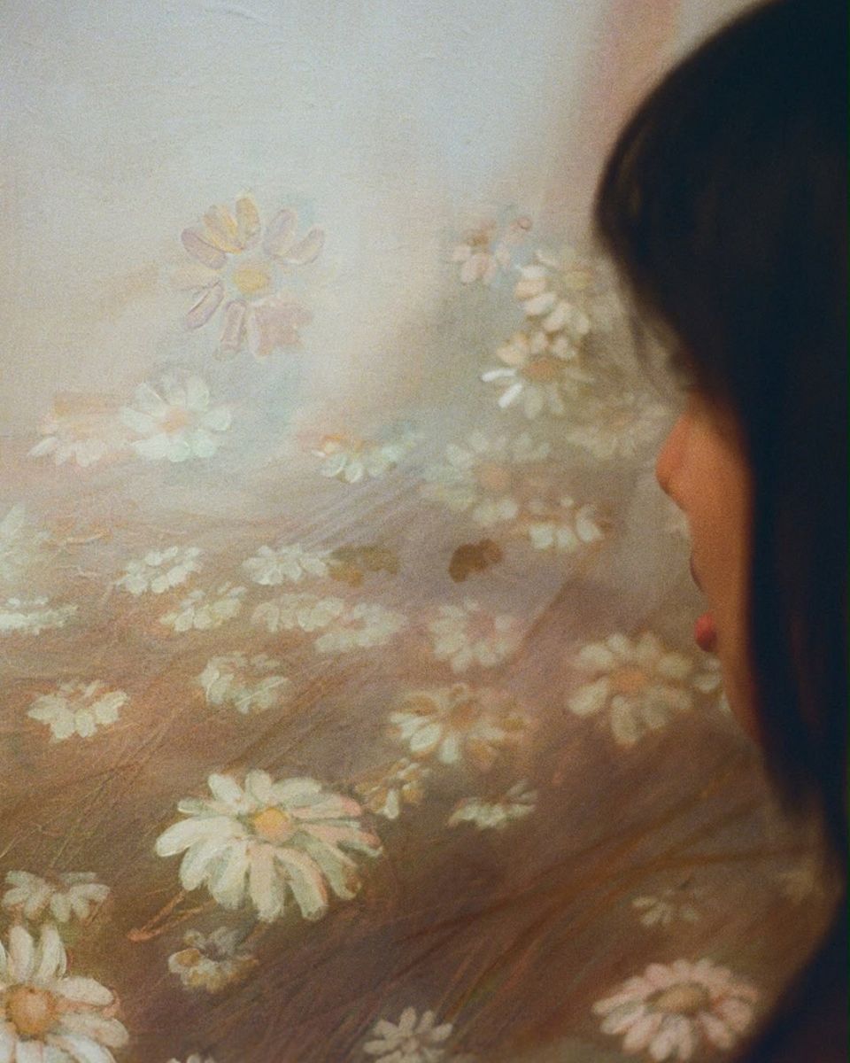 Close-up of a soft-focus oil painting depicting white daisy flowers in a field by Sophia Rosenthal.