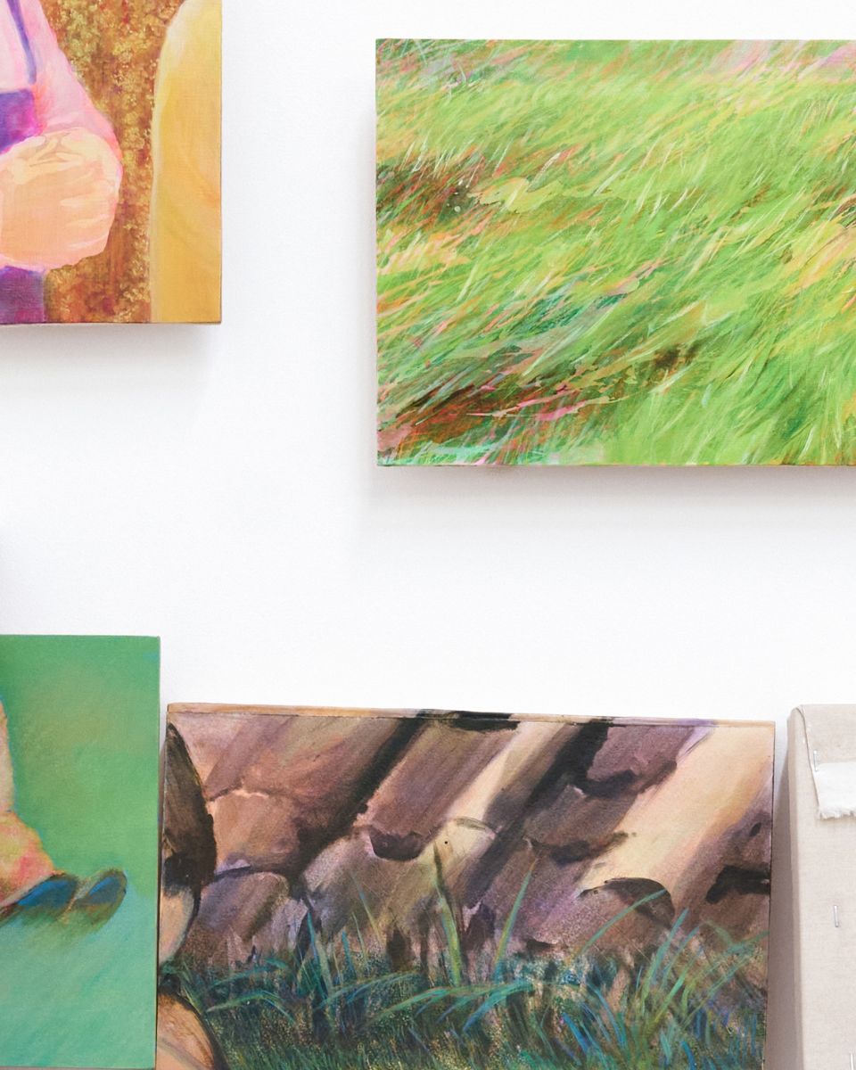 Close-up of small mounted oil paintings showing green grass and landscape textures by Sophia Rosenthal.