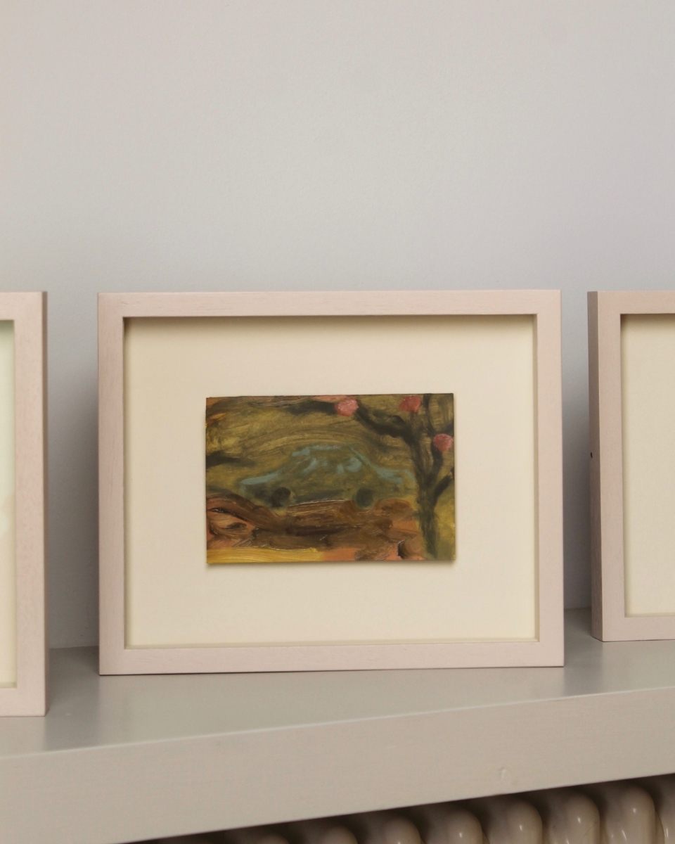 Framed small-scale painting titled Driveby by Sophie Victoria Edwards displayed on a modern grey shelf.