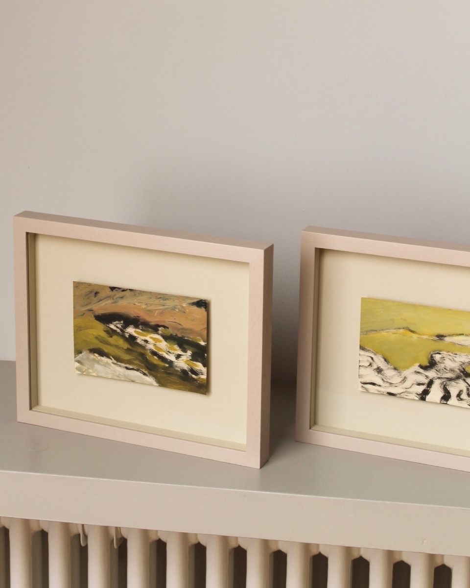 Detail shot of two framed Sophie Victoria Edwards paintings in her studio, showing the elegant pairing of toned colour and framing.