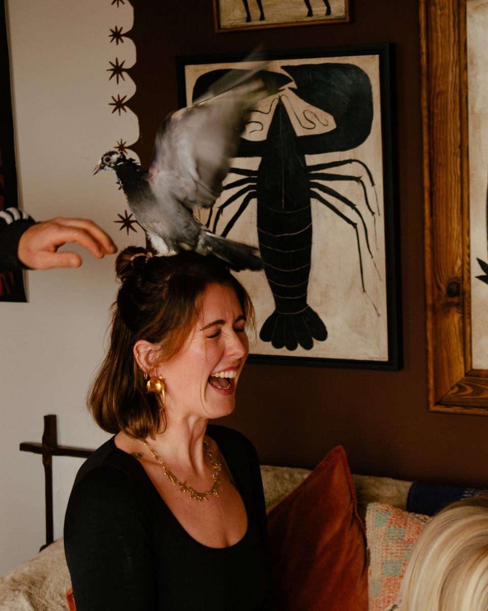 A moving, expressive portrait of artist Tabby Booth in her living room, captured at the moment a bird lands on her head.