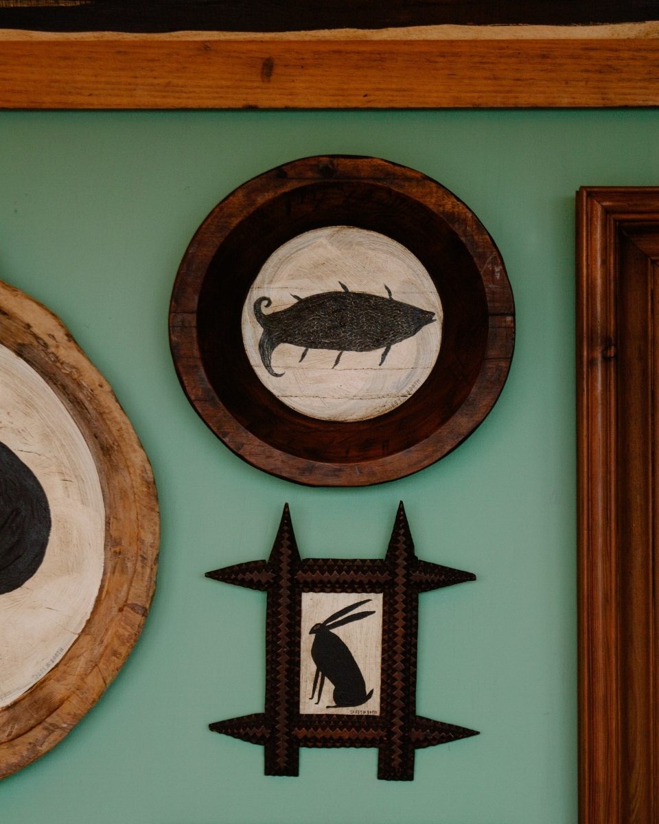 Close-up of two small-scale original artworks mounted on Tabby Booth’s studio wall, highlighting her intricate storytelling.