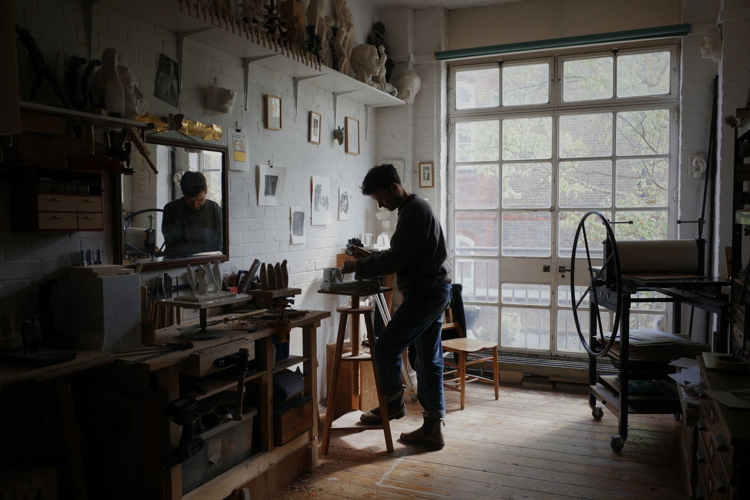 Main banner for Thomas Merrett, depicted carving sculptural figures in his studio for Partnership Editions.