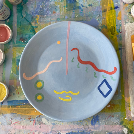 Original ceramic plate, hand-painted by artist Venetia Berry using bold lines and colour to create an abstract figurative design.