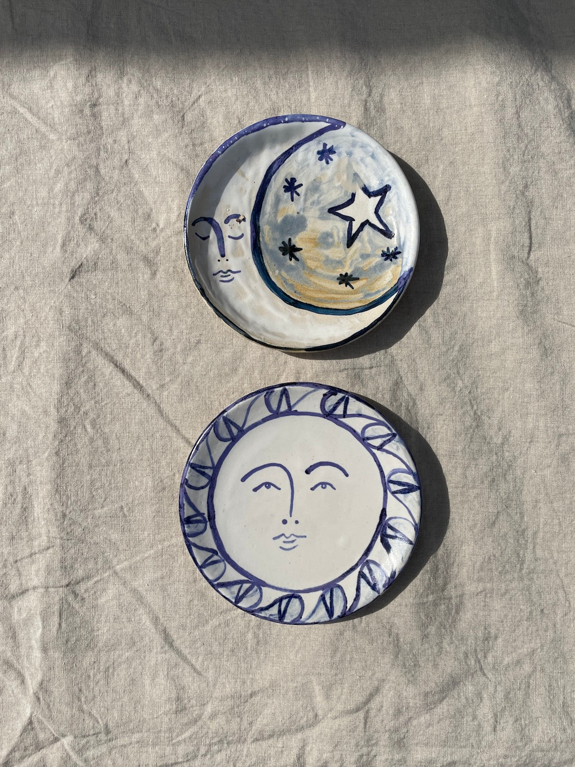 Ceramic plates titled Sun Plate and Moon Plate, painted by the artist Frances Costelloe.