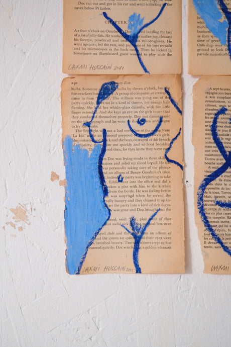 Figurative artwork painted in blue on book pages by the talented artist Laxmi Hussain.