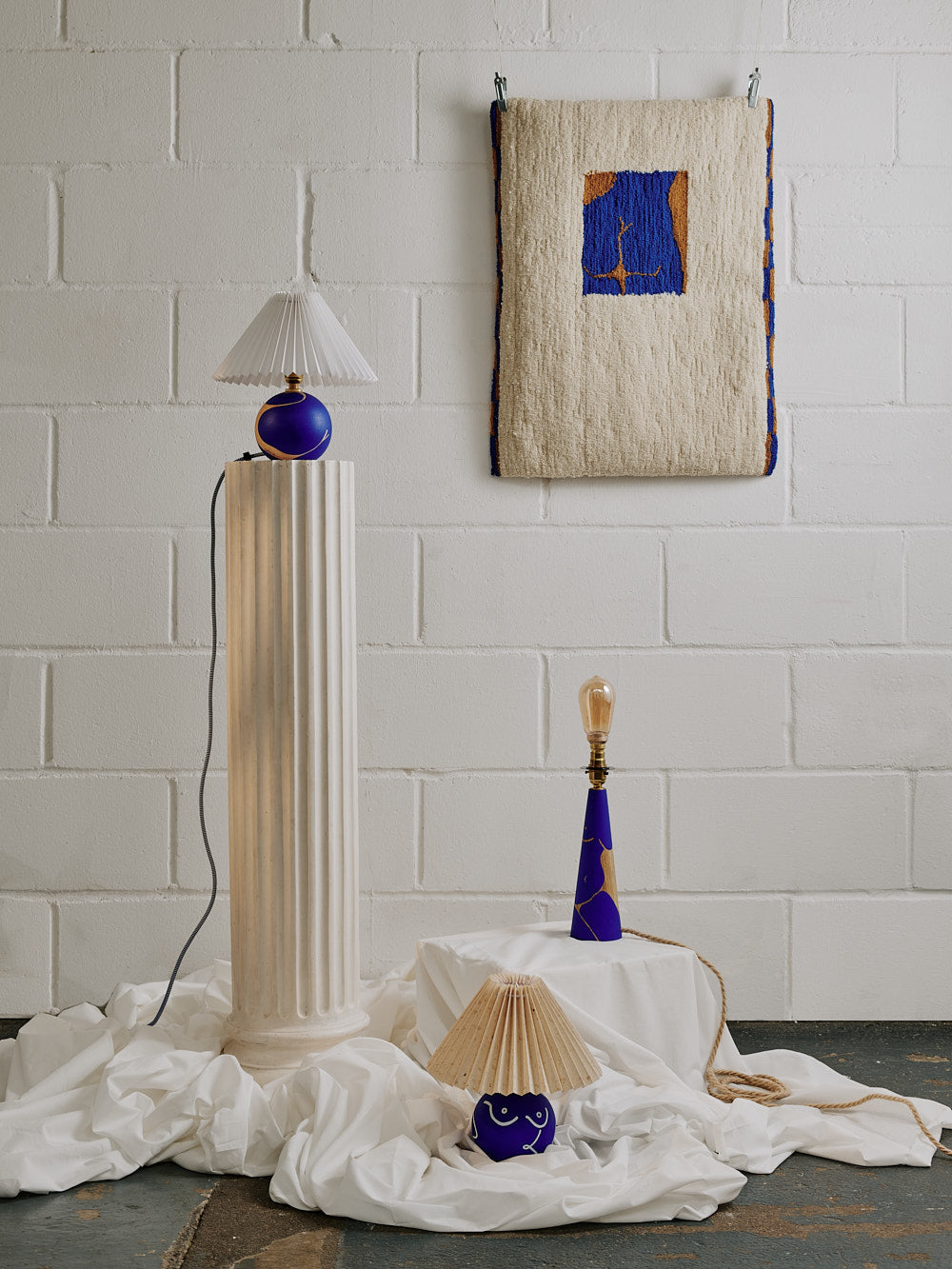 Photograph of rising artist Laxmi Hussain's homeware collection, containing her figurative hand painted wooden lamp titled Elegant Transition 2.