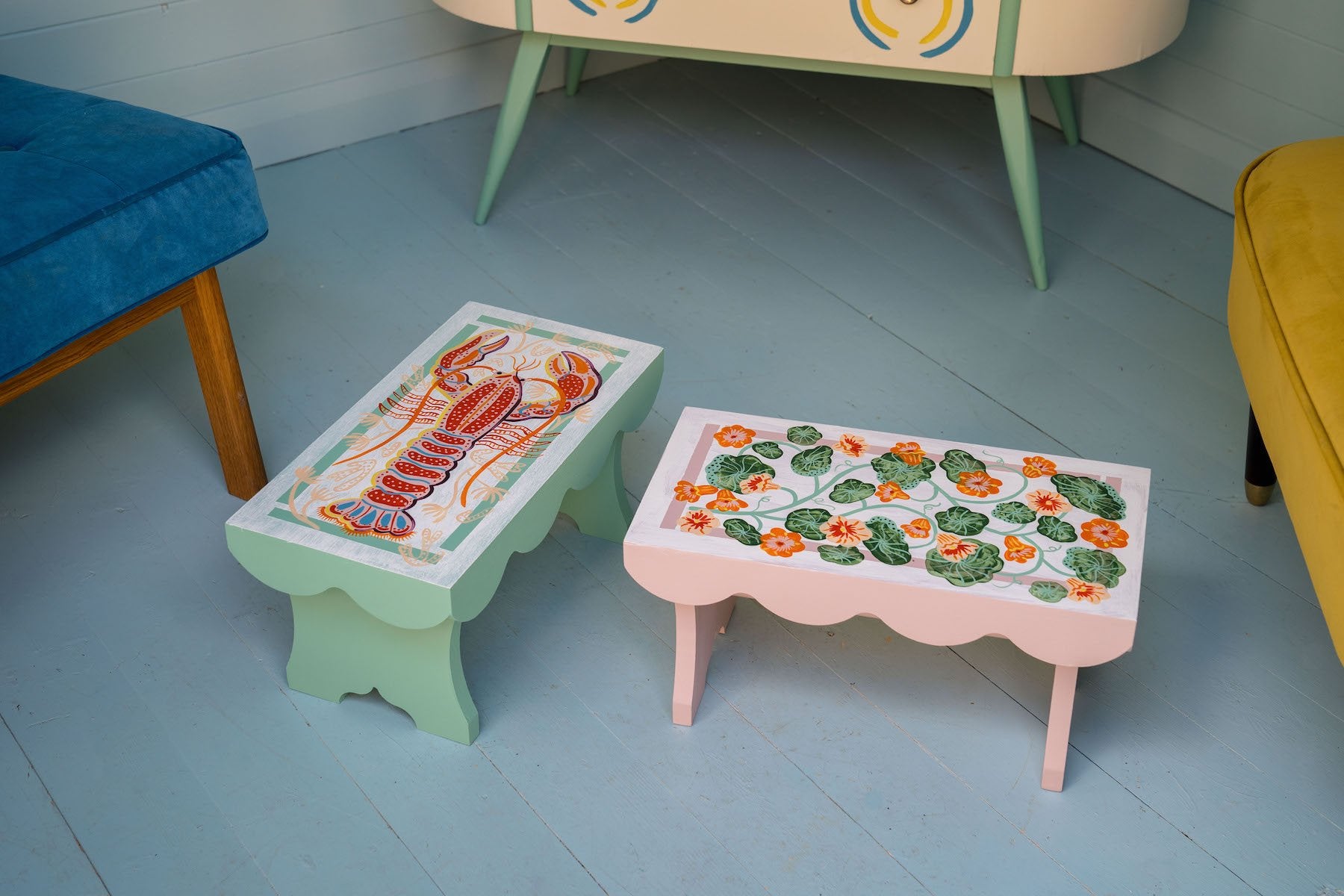 Hand-painted wooden stool titled Nasturtium Stool photographed in Camilla Perkins’ blue shed. 